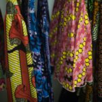 Assortment of colorful african print dresses hanging on rack